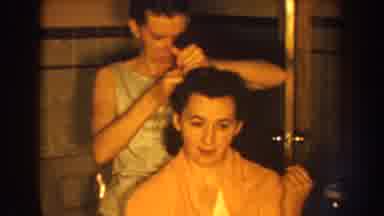 Nebraska (1959): A Woman Sits In A Chair While A Woman Standing Behind Her Combs