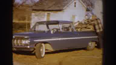 Nebraska (1959): Lumberjacks In Front Of House Putting Wood In The Car