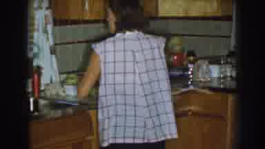 Nebraska (1959): Woman In Sleeveless Plaid Shirt Cooking In Her Big Kitchen