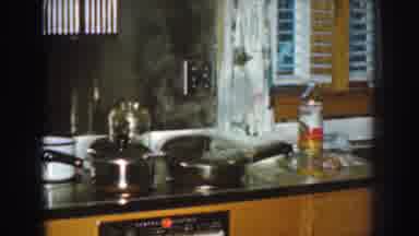 Nebraska (1959): Steam Escapes From Cooking Pan While Woman Wearing White Shirt