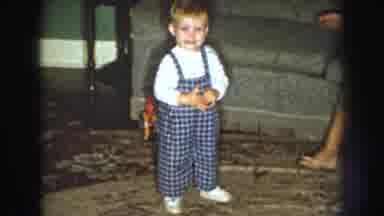 Nebraska (1959): A Small Toddler Who Is Smiling And Dressed In Overalls Inside
