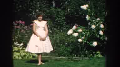 Nebraska (1959): Woman Wearing White Dress Stands Next To Blooming Magnolia Tree