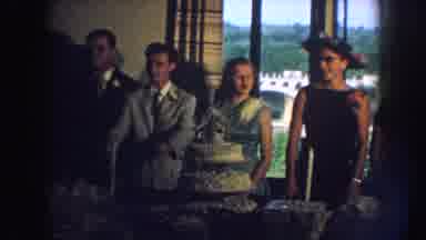 Nebraska (1959): Four People Stand Behind White Two-Tiered Cake Sitting On Long