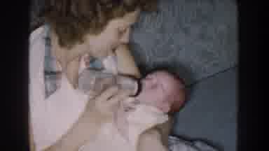 Nebraska (1959): A Mom Is Feeding Her Child With A Baby Bottle