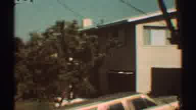 Los Angeles California (1969): View Of Tan Building And White Car Driving Uphill