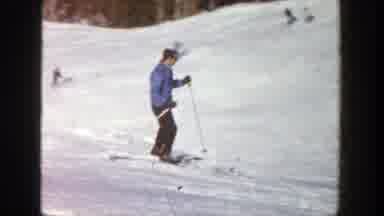 Aspen Colorado (1961): Two Men Wearing Blue Sweaters Ski Downhill On A Sunny Day