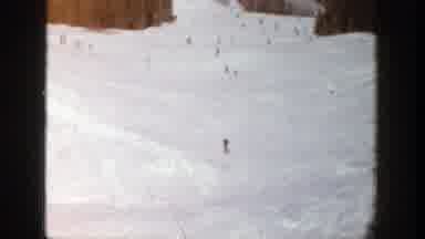 Aspen Colorado (1961): Two People Wearing Blue Coats Ski With Three Other People