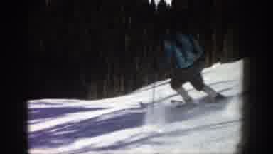 Aspen Colorado-1961: A Person Skiing Down A Snowy Hillside Trees Are In The Background