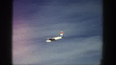 Aspen Colorado (1961): Airplane Flying Over Snow-Covered Area With Tree Posts And