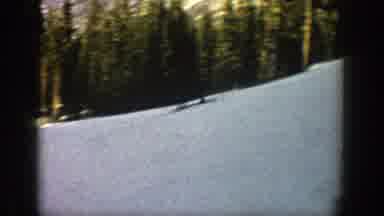 Aspen Colorado (1961): A Person On Skis Skiing Down A Snow Covered Mountain Trail