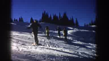 Aspen Colorado (1961): A Group Of People Skiing Down A Snow Covered Hill In A Line