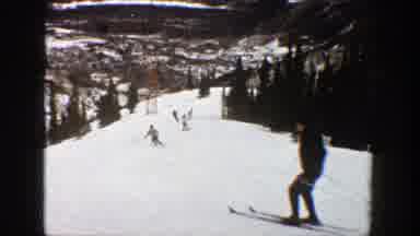 Aspen Colorado (1961): Multiple People Skiing Down A Slope Trees Line The Edges Of