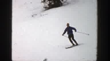 Aspen Colorado (1961): Person Wearing Dark Blue Jacket Skis On A Clear Day