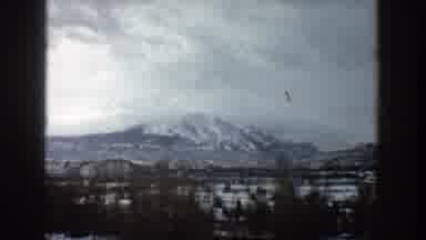 Aspen Colorado (1961): Passing View Of Snow Covered Mountain And Green Trees On A