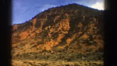 Aspen Colorado (1961): A Large Mountain In The Desert With Trees Covering It