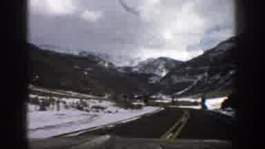 Aspen Colorado (1961): Car Driving On The Road With Snow Covered Mountains In The