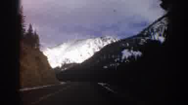 Aspen Colorado (1961): Driving On A Highway Surrounded By Snow-Capped Mountains