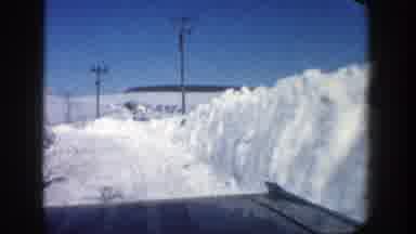 Aspen Colorado (1961): Approaching View Of Snow Banks And A White House On A