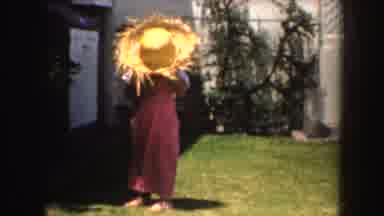 California (1952): Young Girl Getting Her Palm Frond Woven Hat Being Blown Off By
