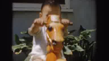 California (1952): Baby Riding Rocking Horse And Mother In Pink Shirt With Purple