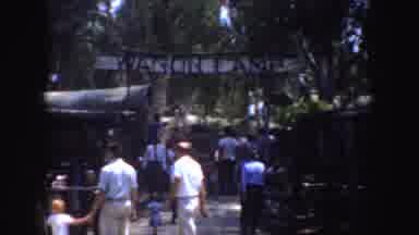 California (1952): View Of Crowd Standing Near Wooden Fence And White Wagon Camp