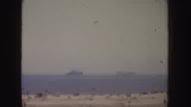 California (1952): People Gathered On The Beach Watching Several Large Ships Out