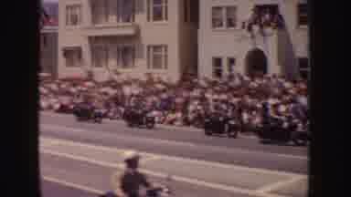 California (1952): Police Officers Riding Motorcycles Through A Parade While Crowd
