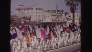 California (1952): Woman Wearing Pink Dress Waves From Blue Car In Parade On A