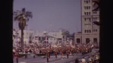 California (1952): Woman Wearing Yellow Swimwear Waves From White Parade Float On