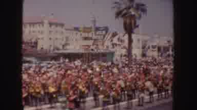 California (1952): A Crowd Of People Watch A Marching Band Perform At A Parade On