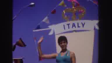 California (1952): Woman On Float Waving During A Parade On A Float With A Flag