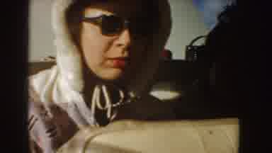 Idaho (1955): Woman Eating In Back Of Car Laughs At Man Wearing Roller Blades And