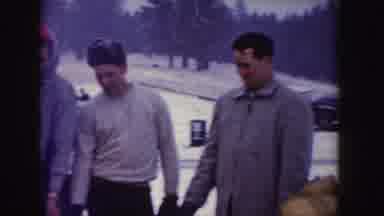 Idaho (1955): Several People Eating Around A Fire On A Snowy Day