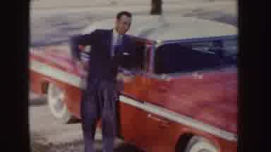 Idaho (1955): Man Walking Up To Red Car Doing Pose Woman Drinking Tea Sitting At