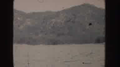 Idaho (1955): View Of Tree Covered Hill And Blue Ocean Water On A Clear Day