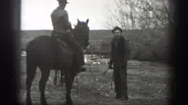 Montana (1939): Man Wearing Black Hat Talks To Person Sitting On Horse On A Clear