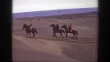 Montana (1939): Three People Ride Brown Horses On Sand On A Cloudy Day