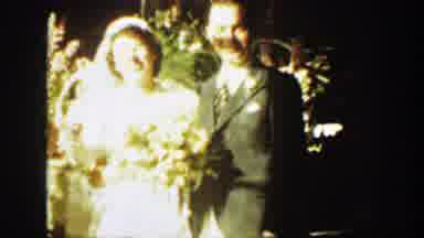 Montana (1939): Man Wearing Grey Suit Kisses Woman Wearing White Dress And Holding