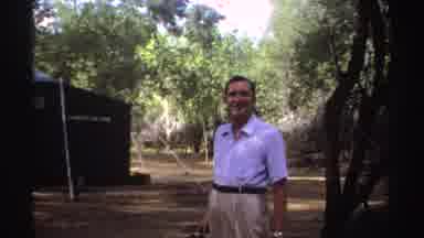 Sudan (1969): Man Wearing Blue Shirt Turns And Walks To Tree On A Clear Day
