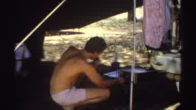 Sudan (1969): Shirtless Man Sitting Under Tent Talking On Radio With Car With Hood