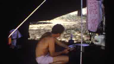 Sudan (1969): Man In A Tent Interacts With Electronic Device Green Area And Trees