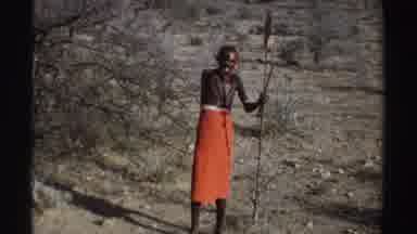 Sudan (1969): View Of Black Wildebeest And Person Wearing Orange Cloth And Holding