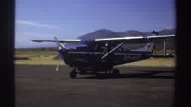 Sudan (1969): Two Men Stand Next To A Jeep And A Small Airplane At An Airport