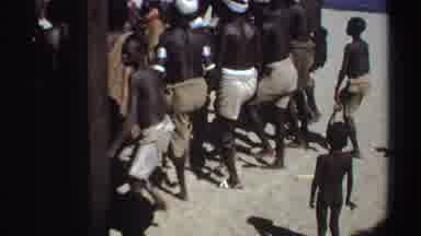 Sudan (1969): Large Group Of People Dancing On Sand On A Bright Sunny Day