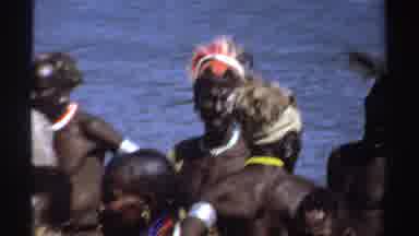 Sudan (1969): People Wearing African Tribal Wear Standing Near A Body Of Water