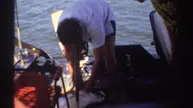 Sudan (1969): Woman Wearing White Head Scarf Watches Man Remove Hook From Fish