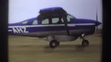 Sudan (1969): A Small Blue Airplane Or Jet Passing Through A Grass Field