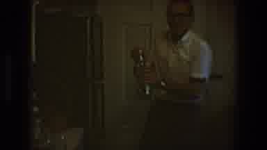 Toledo Ohio (1968): Dark Video Of A Man Wearing A White Shirt Inside Of A Building