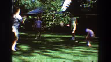 Toledo Ohio (1968): Four People Playing Badminton On Green Grass On A Sunny Day