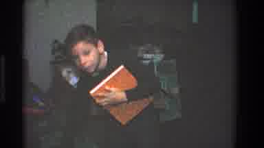 Toledo Ohio (1968): Boy Wearing Blue Shirt Holds Up Red And Orange Jokes Book